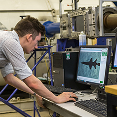 Researcher operating MACE wind tunnel computer equipment