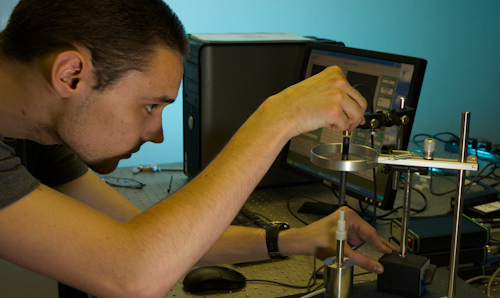 Student adjusting a piece of equipment in lab