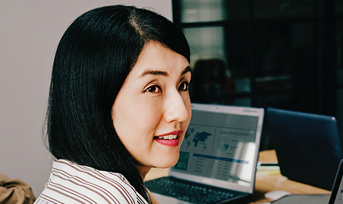 Women sat in an office smiling at a computer screen